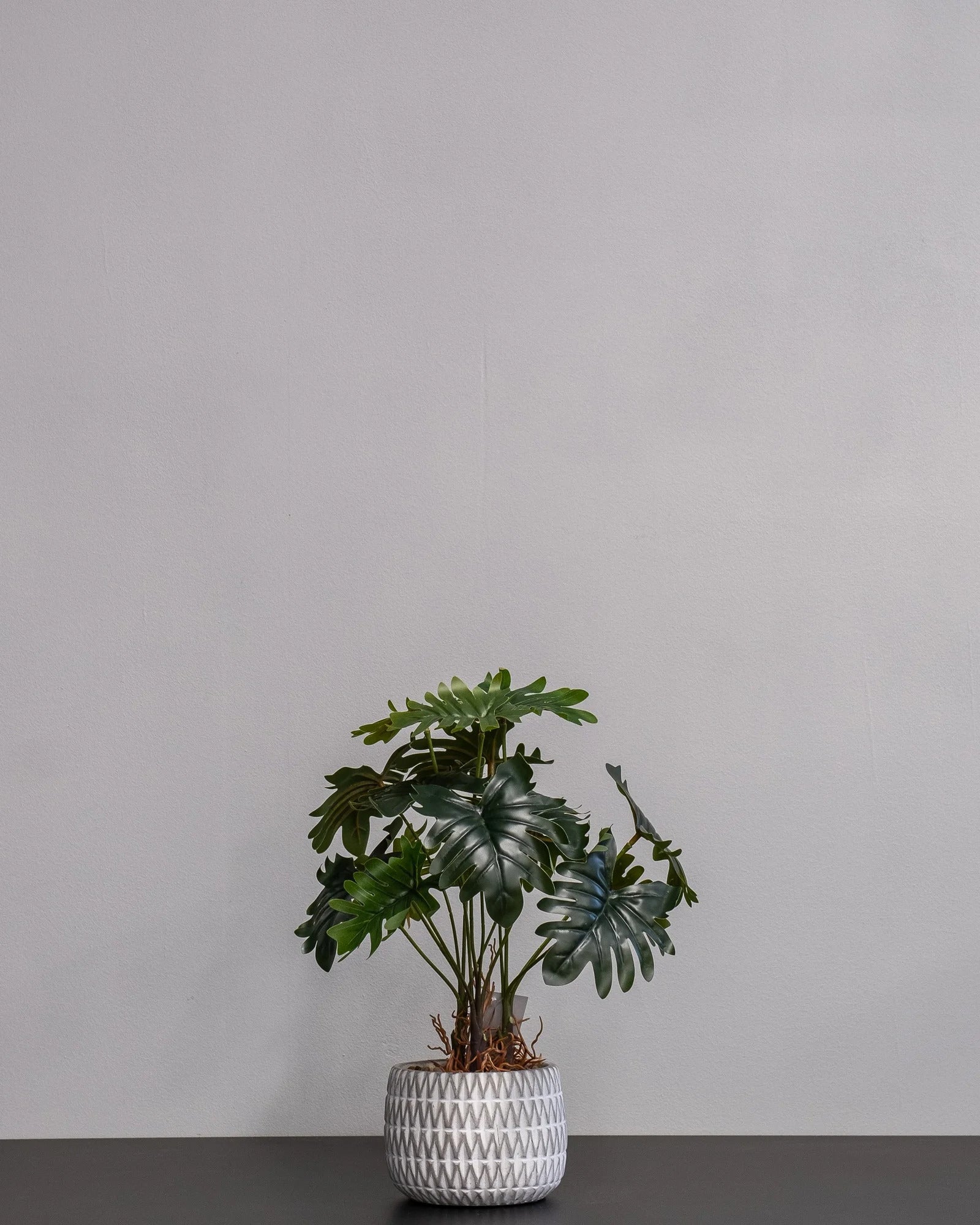 Närbild på detaljerna i Konstgjord Filodendron krukväxt med cementkruka – 32 cm