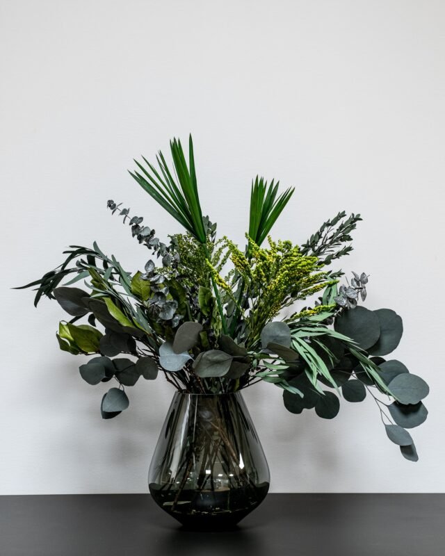 Grön Bukett - En frodig torkad blombukett med olika sorters eucalyptus och gröna blad i en modern inredningsmiljö.